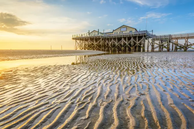 Beach with a pier at sunset in Sankt Peter-Ording